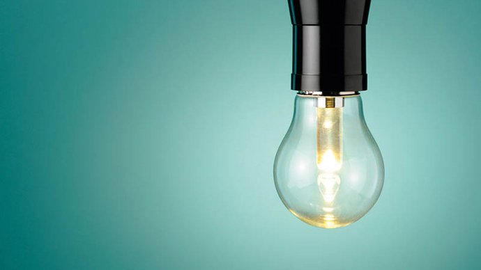 Glühlampe vor türkisem Hintergrund